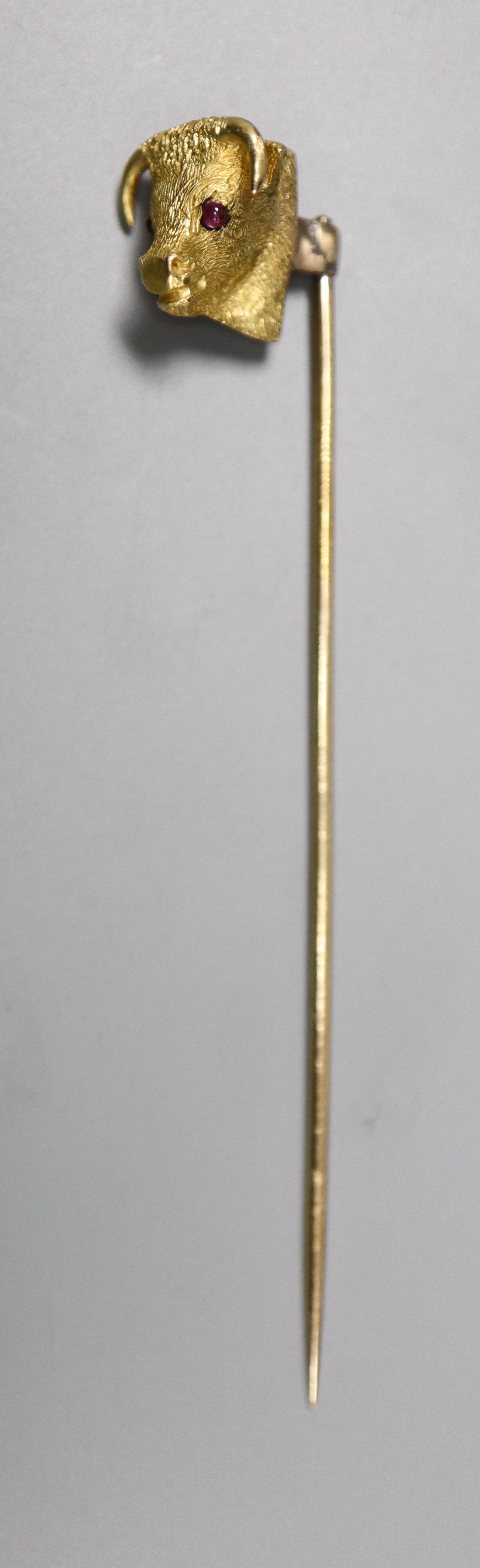 An Edwardian yellow metal and garnet set bulls head stick pin, 65mm, gross 4.4 grams.